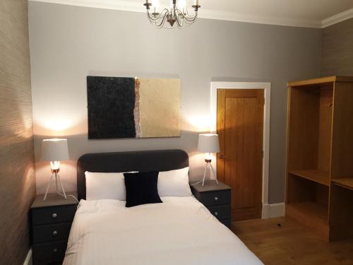a bedroom with a bed with two night stands and two lamps at Signature Apartments in Fraserburgh