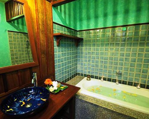 Villa Korbhun Khinbua في شيانغ ماي: حمام مع حوض استحمام ومغسلة زرقاء