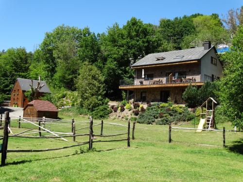 a farm house with a fence and a playground at Relais des Eveux in La Roche-en-Ardenne
