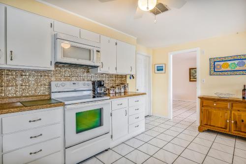 a kitchen with white cabinets and a stove top oven at Sapphire Sabbatical in Key West