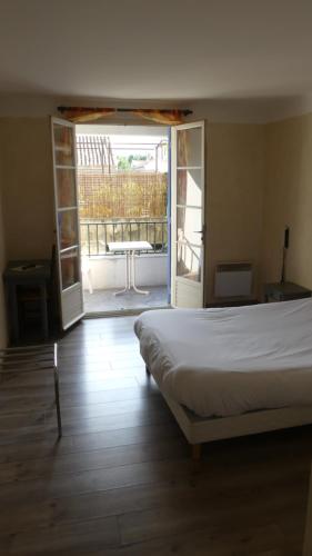 une chambre avec un lit et une porte ouverte sur un patio dans l'établissement Abri Du Ventoux, à Malaucène