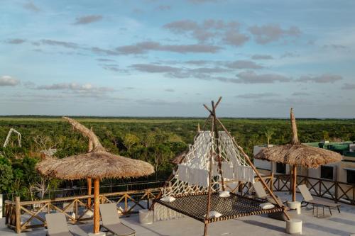 - une vue depuis le toit d'un complexe avec des parasols en paille dans l'établissement Naala Tulum, à Tulum