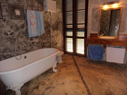 La salle de bains est pourvue d'une baignoire et de toilettes. dans l'établissement Jardim Botânico ME-ZOCHI, à Vila Moura