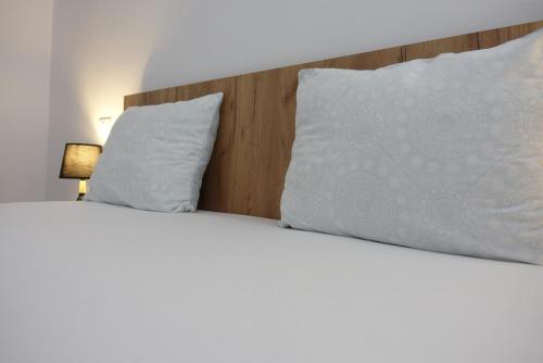 a bedroom with two beds with white pillows at Balcescu Apartment Self Check-in in Timişoara