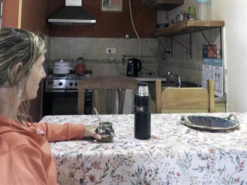 Una donna seduta a un tavolo in una cucina di Cabaña entre Arboles a San Carlos de Bariloche
