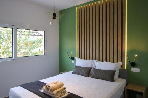 um quarto com uma cama com paredes verdes e uma janela em Phaedrus Living: Seaside Modern Flat Limnaria 123 em Paphos