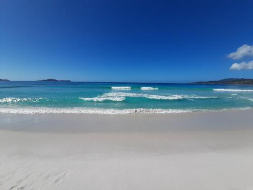 a beach with the ocean and a blue sky at Casa Estelar in Cabo Frio