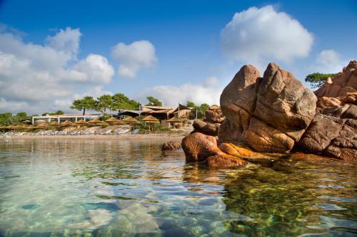 a view of a beach with rocks in the water at La Plage Casadelmar in Porto-Vecchio