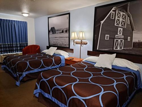 a hotel room with two beds and a picture of a barn at Super 8 by Wyndham Three Hills AB in Three Hills