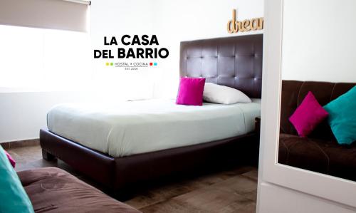 a bedroom with a bed with pink pillows and a couch at La Casa del Barrio in Monterrey