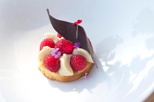 a dessert with raspberries on a white plate at La Plage Casadelmar in Porto-Vecchio