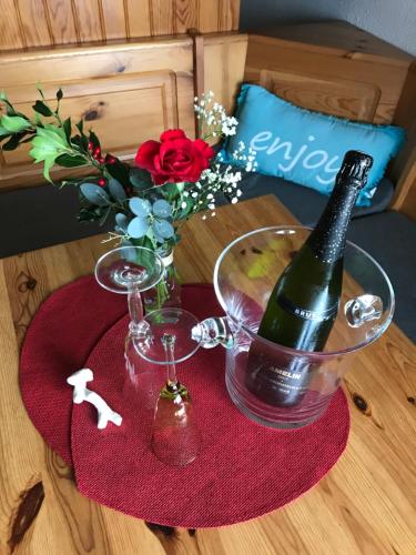 a bottle of wine and two glasses on a table at Les Marinas de Cassy in Lanton