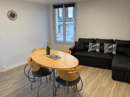 un salon avec une table et un canapé dans l'établissement L’Escapade Normande, au Tréport