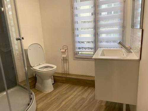 une salle de bain avec toilettes, lavabo et fenêtre dans l'établissement L’Escapade Normande, au Tréport
