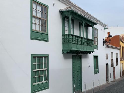 ein weißes Gebäude mit grünen Fenstern und einem Balkon in der Unterkunft Casa Emblemática Don Gabriel in Santa Cruz de la Palma