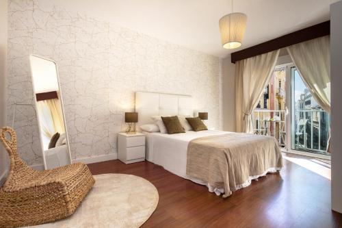 マラガにあるExclusive Apartments Street Beatasのベッドルーム1室(ベッド1台、椅子、窓付)