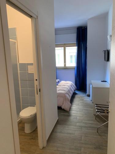 a bedroom with a bed and a toilet and a window at BONORUM De Spuches in Palermo