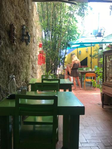 a group of green tables and chairs in a patio at La Casa del Barrio in Monterrey