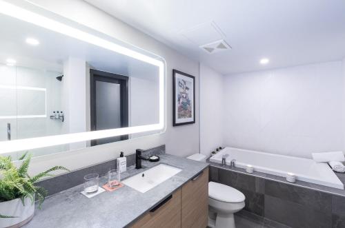a bathroom with a tub and a sink and a toilet at The Crystal Lodge in Whistler