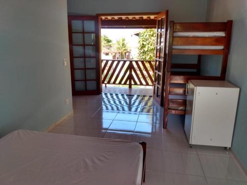Habitación con cama y puerta a un balcón. en Casa na praia do estaleiro, en Ubatuba