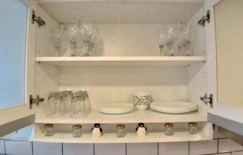 a kitchen with glasses and plates on shelves at Moderno departamento en San Telmo in Buenos Aires