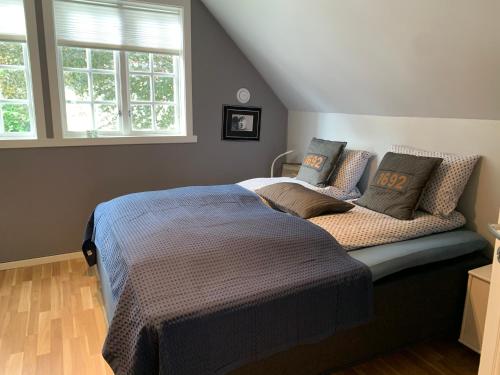 a bedroom with a bed and two windows at Høyanger 3 roms leilighet in Høyanger