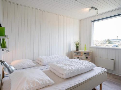 2 Betten in einem weißen Zimmer mit Fenster in der Unterkunft Holiday home Hvide Sande LXIX in Havrvig