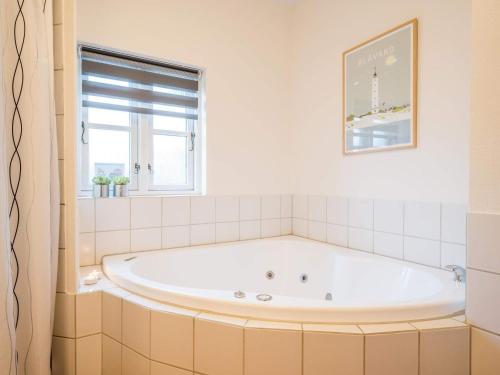 een badkamer met een bad en een raam bij Holiday home Blåvand CXCVII in Blåvand