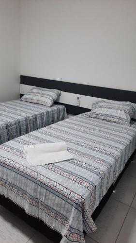 two beds sitting next to each other in a room at Lindo Apartamento Varanda no centro de Paulo Afonso in Paulo Afonso