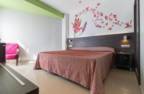 a bedroom with a bed with a red blanket at Hotel Porto Calpe in Calpe