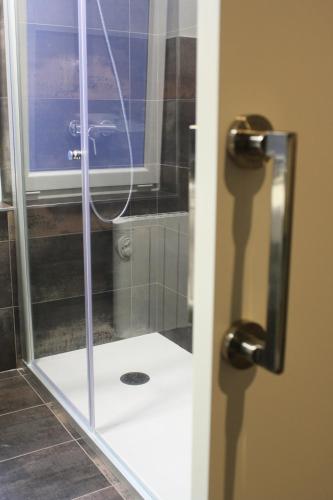 a shower with a glass door with a window at Los Balcones del Arte in Santander