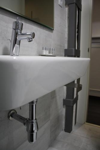 a white sink in a bathroom with a mirror at Los Balcones del Arte in Santander
