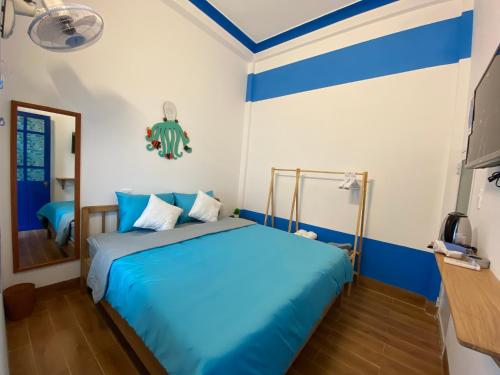 a bedroom with blue and white walls and a bed at Cát Homestay in Quy Nhon