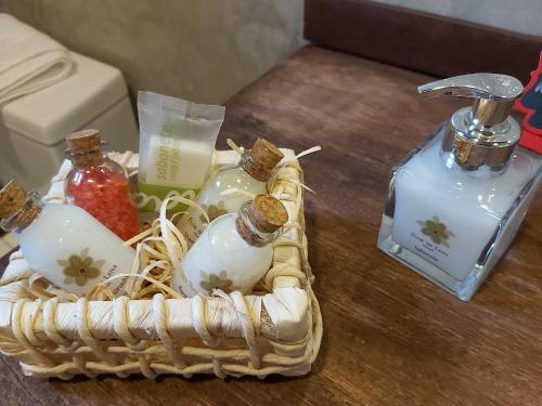 una cesta con botellas de perfume en una mesa en Pousada Flor de Lena Icaraizinho - Suíte Jasmim, en Icaraí