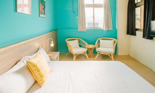 a bedroom with a bed and two chairs and a table at Fun Trip - Fu May Sea View Holiday house l 無敵海景交誼廳 l 附汽機車租賃 l in Taitung City