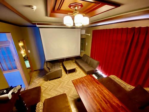 a room with a screen and a couch and a table at 貸切御宿Villa EL 5 Nikko Kinugawa Area in Nikko