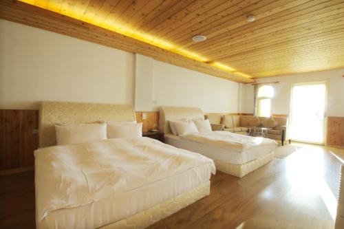 a large bedroom with two beds and a couch at Cingjing Brilliant Twins of Seattle in Renai