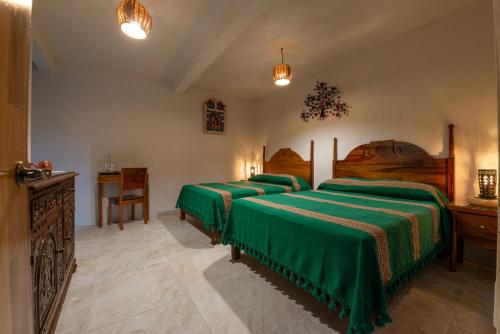 a bedroom with two beds and two lamps at La Casa Carlota in Oaxaca City