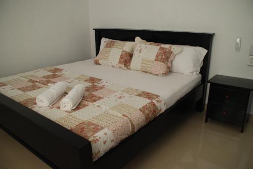 a bed with two pillows and a quilt on it at Hotel Coastalbay 2 & Golf Cart Rental in San Pedro