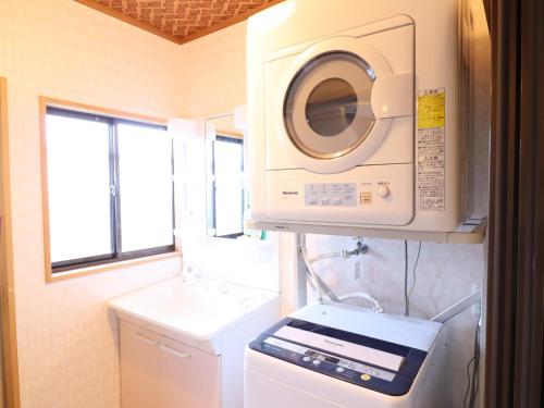 a laundry room with a washer and a washing machine at Friendly Guest House Kawakin in Minamiboso