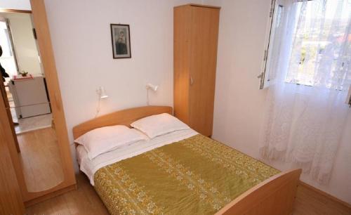 ein kleines Bett in einem Zimmer mit Fenster in der Unterkunft Apartments Amalija-50m close to sea in Rogoznica