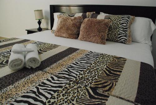 a bed with a black and white comforter and pillows at Hotel Coastalbay 2 & Golf Cart Rental in San Pedro