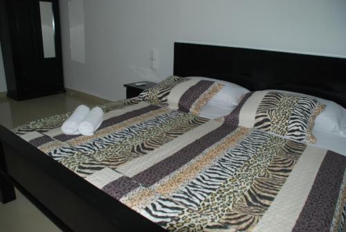 a bed with a cheetah blanket and pillows on it at Hotel Coastalbay 2 & Golf Cart Rental in San Pedro