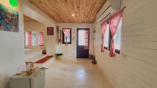 a hallway of a house with a door and windows at Maliblues Bed & Art Gallery in Chumphon