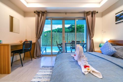 a bedroom with a bed and a desk and a table at Dreambeach 2-villas in Panwa Beach