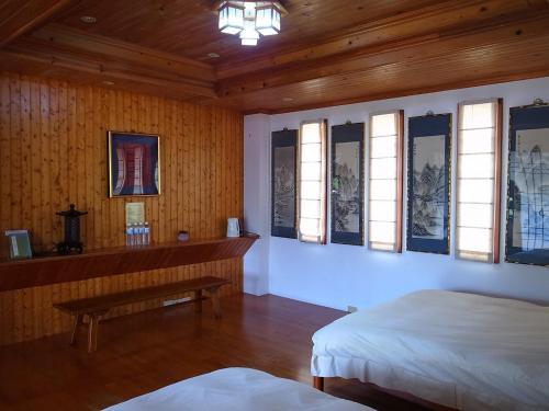 Zimmer mit 2 Betten, einer Bank und Fenstern in der Unterkunft The LianFamily Teahouse B&B台東民宿001號 in Yung-an-ts'un