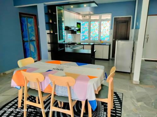 uma cozinha com uma mesa com 4 cadeiras e uma cozinha com em imanAdam Laguna Apartment em Porto Dickson