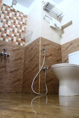 La salle de bains est pourvue d'une douche et de toilettes. dans l'établissement THE CHENNAI INN, à Chennai