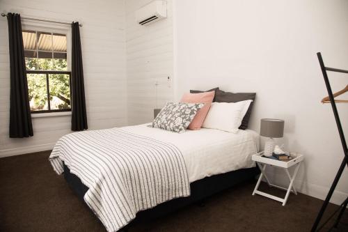 a bedroom with a bed and a window at The Glen Farmhouse on Ovens River in Wangaratta
