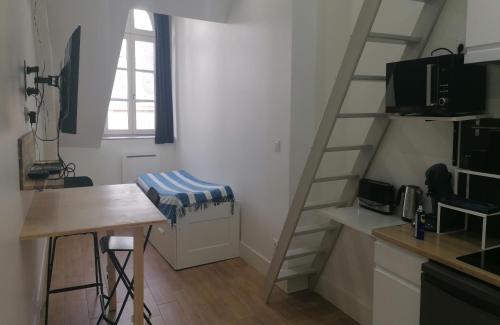 cocina con escalera y mesa en una habitación en Studio plein de charme - 2, en Orléans